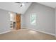 Carpeted bedroom with a vaulted ceiling, natural light, and a barn door leading to a closet at 1940 Country Pl, Cumming, GA 30040