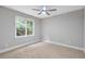 Cozy bedroom featuring neutral carpet, a ceiling fan, and a window that fills the space with natural light at 1940 Country Pl, Cumming, GA 30040