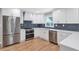 Modern kitchen boasts stainless steel appliances, white cabinets, and hardwood flooring at 1940 Country Pl, Cumming, GA 30040