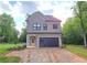 Charming two-story home with brick accents, a modern garage door, and lush green surroundings at 41 Birch Ct, Mcdonough, GA 30253