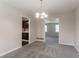 Bright dining room with gray carpet and neutral walls, featuring a chandelier and views into other rooms at 4331 Wrexham Ct, Snellville, GA 30039