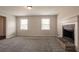 This living room boasts ample natural light, a stone fireplace, and neutral carpet at 4331 Wrexham Ct, Snellville, GA 30039