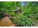 Lush backyard landscaping with a wooden walkway leading to a screened-in porch and back deck at 1736 Morris Landers Ne Dr, Atlanta, GA 30345