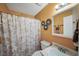 Cozy bathroom with vanity, toilet, tub, shower curtain, mirror, and peach colored walls at 2056 Merle Se Dr, Conyers, GA 30013