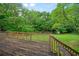View of the wooden deck and lush green backyard with mature trees at 2056 Merle Se Dr, Conyers, GA 30013
