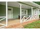 Close-up of the front porch with seating and a decorative railing and front door at 2056 Merle Se Dr, Conyers, GA 30013