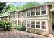 Exterior view of a two-story home with brown siding and white trim surrounded by mature trees and landscaping at 5145 Roswell Road # 3, Atlanta, GA 30342