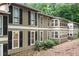 Exterior view of a two-story home with brown siding and black shutters surrounded by mature trees and landscaping at 5145 Roswell Road # 3, Atlanta, GA 30342
