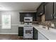 Modern kitchen with sleek black cabinets, white countertops, and new stainless steel appliances, ready for cooking at 7384 Birch Hollow Pl, Douglasville, GA 30134