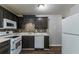 Well-lit kitchen features dark cabinetry, new appliances, and stylish backsplash, perfect for Gathering meals at 7384 Birch Hollow Pl, Douglasville, GA 30134