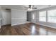 Bright living room featuring hardwood floors, neutral walls, ceiling fan, and natural light from large windows at 7384 Birch Hollow Pl, Douglasville, GA 30134