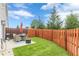 Green backyard and patio area with an outdoor dining set, barbecue grill, and a privacy fence at 739 Woodstock Grove Dr, Woodstock, GA 30188
