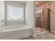 Bathroom featuring a soaker tub, separate tiled shower with glass door and lots of natural light at 739 Woodstock Grove Dr, Woodstock, GA 30188