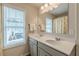 Bright bathroom with a double sink vanity, a large mirror and light-filled windows at 739 Woodstock Grove Dr, Woodstock, GA 30188