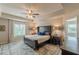 Spacious bedroom featuring a tray ceiling, ceiling fan, and large windows for natural light at 739 Woodstock Grove Dr, Woodstock, GA 30188
