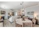 Dining area features seating for four and a modern chandelier, adjacent to the living room at 739 Woodstock Grove Dr, Woodstock, GA 30188