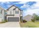 Charming two-story home boasts a stone-accented garage and manicured lawn under a partly cloudy sky at 739 Woodstock Grove Dr, Woodstock, GA 30188