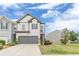 Charming two-story home with a gray facade, manicured lawn, and a cozy front porch at 739 Woodstock Grove Dr, Woodstock, GA 30188