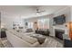 Bright living room features a fireplace, ceiling fan, and a large sectional sofa at 739 Woodstock Grove Dr, Woodstock, GA 30188