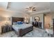 Spacious main bedroom boasts a ceiling fan, large bed, with attached seating and vanity area with lots of natural light at 739 Woodstock Grove Dr, Woodstock, GA 30188