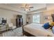 A bright main bedroom features a decorative rug, large bed, ceiling fan and desk area with lots of natural light at 739 Woodstock Grove Dr, Woodstock, GA 30188