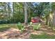 Green chairs surround a fire pit in the backyard of this home, with a red shed and mower in the background at 854 Parkway Se Dr, Smyrna, GA 30080