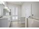 Bright bathroom featuring double vanities, ample storage, and a walk-in tub at 1126 Wedgefield Sw Dr, Marietta, GA 30064