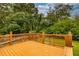A raised wooden back deck overlooks the lush green lawn and mature trees in the backyard at 2191 Fairfield Se St, Smyrna, GA 30080