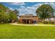 A sprawling backyard showcases a multi-level deck, a lush lawn, a dark grey garage door, and mature trees at 2191 Fairfield Se St, Smyrna, GA 30080