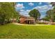 Exterior view of a brick house with a wooden deck, lush green backyard, and a concrete driveway at 2191 Fairfield Se St, Smyrna, GA 30080