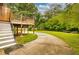View of a spacious backyard with a wooden deck, a winding concrete driveway, and lush green lawn at 2191 Fairfield Se St, Smyrna, GA 30080