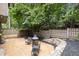 Secluded backyard featuring a fire pit area with gravel and black mulch, surrounded by lush trees and a wooden fence at 225 Lakeview W Rdg, Roswell, GA 30076