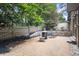 Backyard area featuring a fire pit, chairs, and a gravel area, with lush trees and a wooden fence in the background at 225 Lakeview W Rdg, Roswell, GA 30076