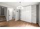 Bright bedroom with built-in shelves, light fixture, wood floors, stairs, and a view into the powder room at 225 Lakeview W Rdg, Roswell, GA 30076