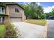 View of the home's exterior, including a driveway, a green lawn, and mature trees at 225 Lakeview W Rdg, Roswell, GA 30076