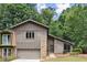 Charming home featuring a stone accent wall, front-facing garage, and well-manicured lawn at 225 Lakeview W Rdg, Roswell, GA 30076