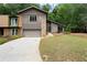 This home has a stone accent wall, a front-facing garage, and a well-manicured front yard at 225 Lakeview W Rdg, Roswell, GA 30076