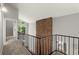 Upstairs hallway featuring an exposed brick chimney and iron railing overlooking the main level at 225 Lakeview W Rdg, Roswell, GA 30076