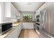 Bright kitchen with stainless steel appliances, granite countertops, and a window view of the lush outdoors at 225 Lakeview W Rdg, Roswell, GA 30076