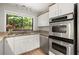 Bright kitchen with stainless steel appliances, granite countertops, and a window view of the lush outdoors at 225 Lakeview W Rdg, Roswell, GA 30076