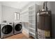 Laundry room with front-load washer and dryer, lots of storage shelves and a water heater at 225 Lakeview W Rdg, Roswell, GA 30076