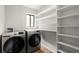 Convenient laundry room features a window, shelving, and stainless steel washer and dryer at 225 Lakeview W Rdg, Roswell, GA 30076