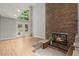 Bright living room with a brick fireplace, wood floors, and access to the outdoors at 225 Lakeview W Rdg, Roswell, GA 30076