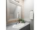 Powder room with a large framed mirror, gray vanity, decorative accent wall and a towel at 225 Lakeview W Rdg, Roswell, GA 30076