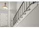 Carpeted staircase with a black railing next to a white wall under a pendant light at 225 Lakeview W Rdg, Roswell, GA 30076