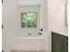 Bathroom features a white tub with a window view, and a vanity with gold hardware at 3473 Shoal Oak Ct, Riverdale, GA 30296