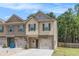 Charming two-story townhome with single-car garage and manicured lawn at 3473 Shoal Oak Ct, Riverdale, GA 30296