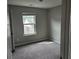 A cozy bedroom with carpet, a bright window, and neutral walls at 6585 Story Cir, Norcross, GA 30093