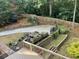 Landscaped backyard with a concrete patio, stone walls, and wooden fencing at 107 Sedgefield Overlook, Dallas, GA 30157