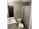 Bathroom features a vanity with a single sink, toilet, and shelving; a functional and tidy space at 107 Sedgefield Overlook, Dallas, GA 30157